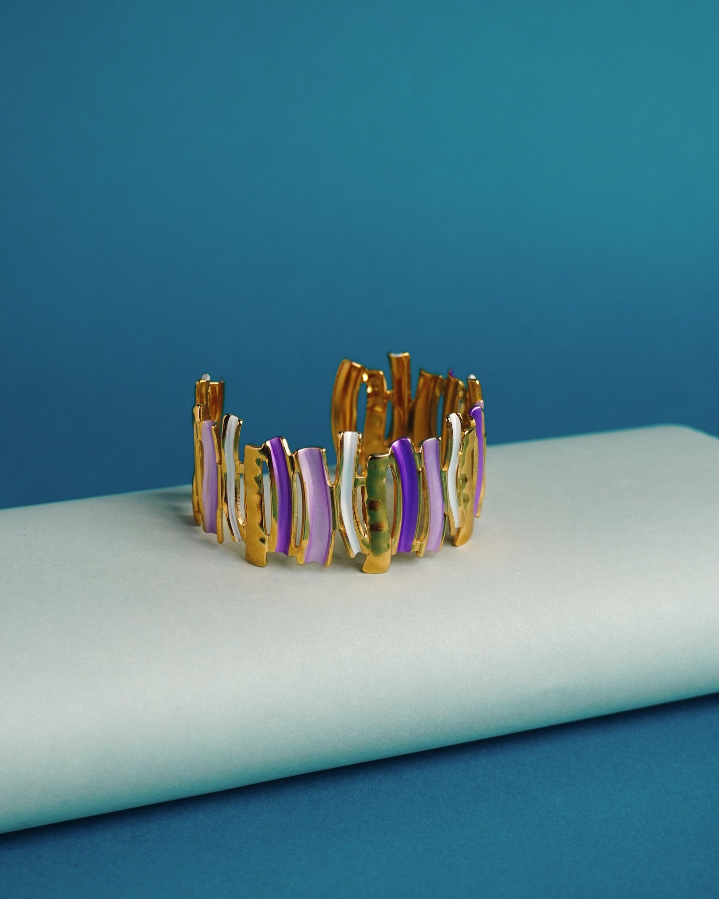 Multicolored bracelet on a white surface with a blue background
