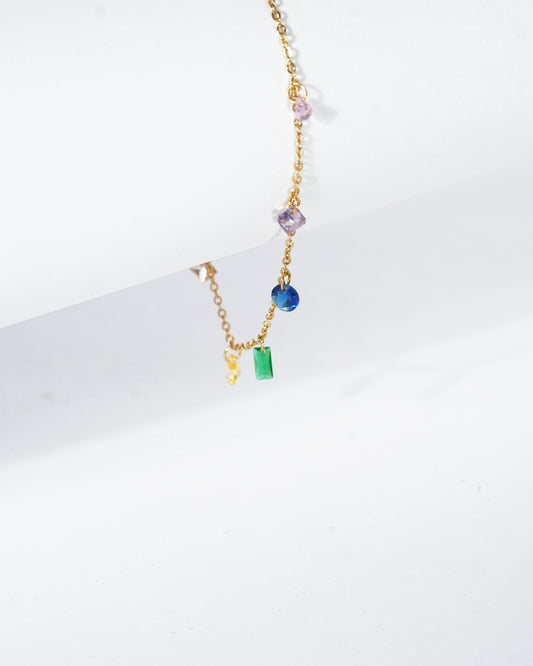 Gold necklace with colorful beads on a white background
