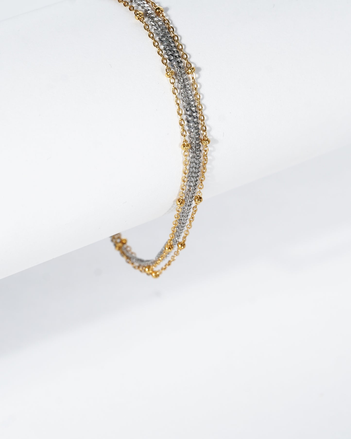 Gold and silver beaded necklace on a white background