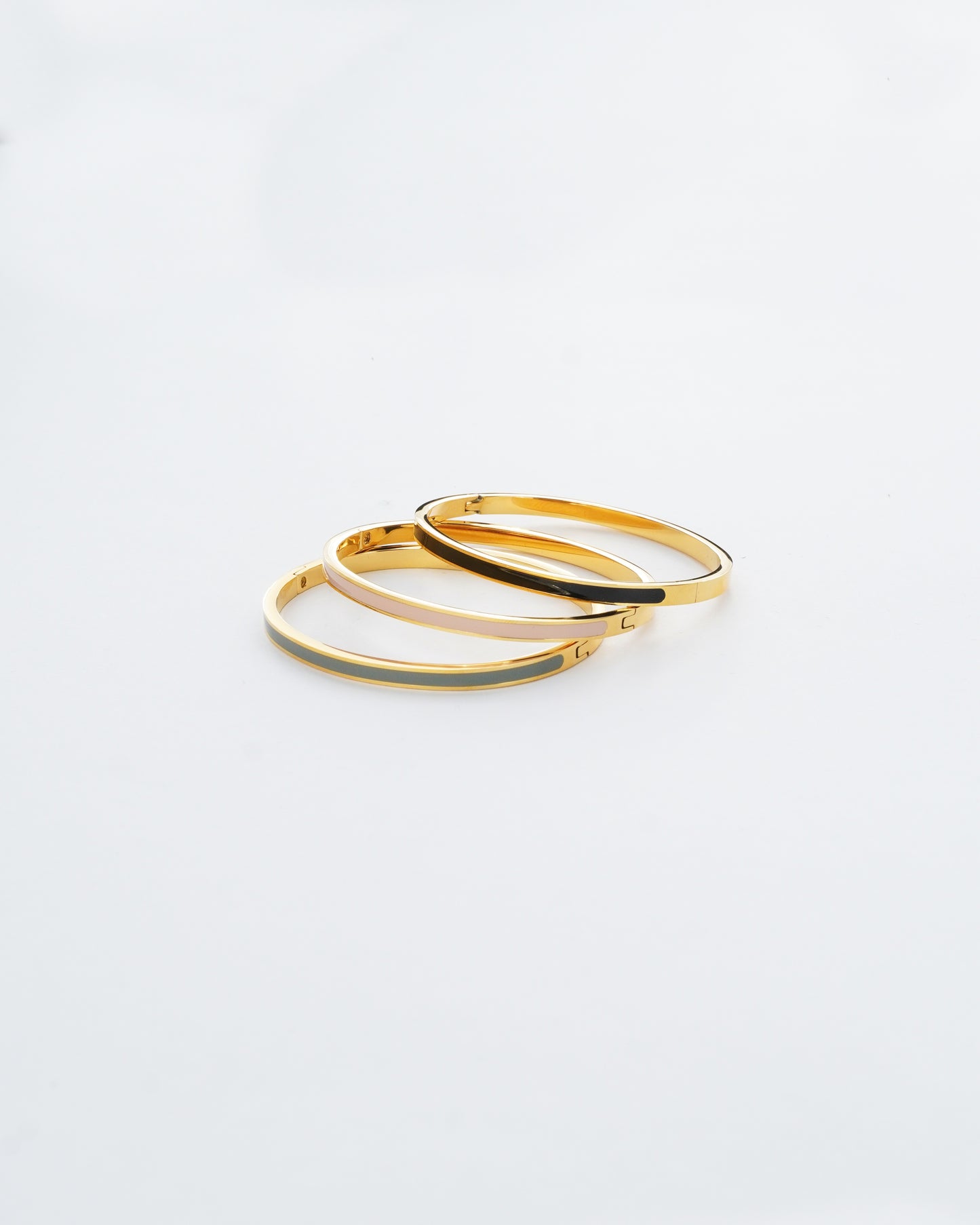 Two gold hoop earrings on a light gray background