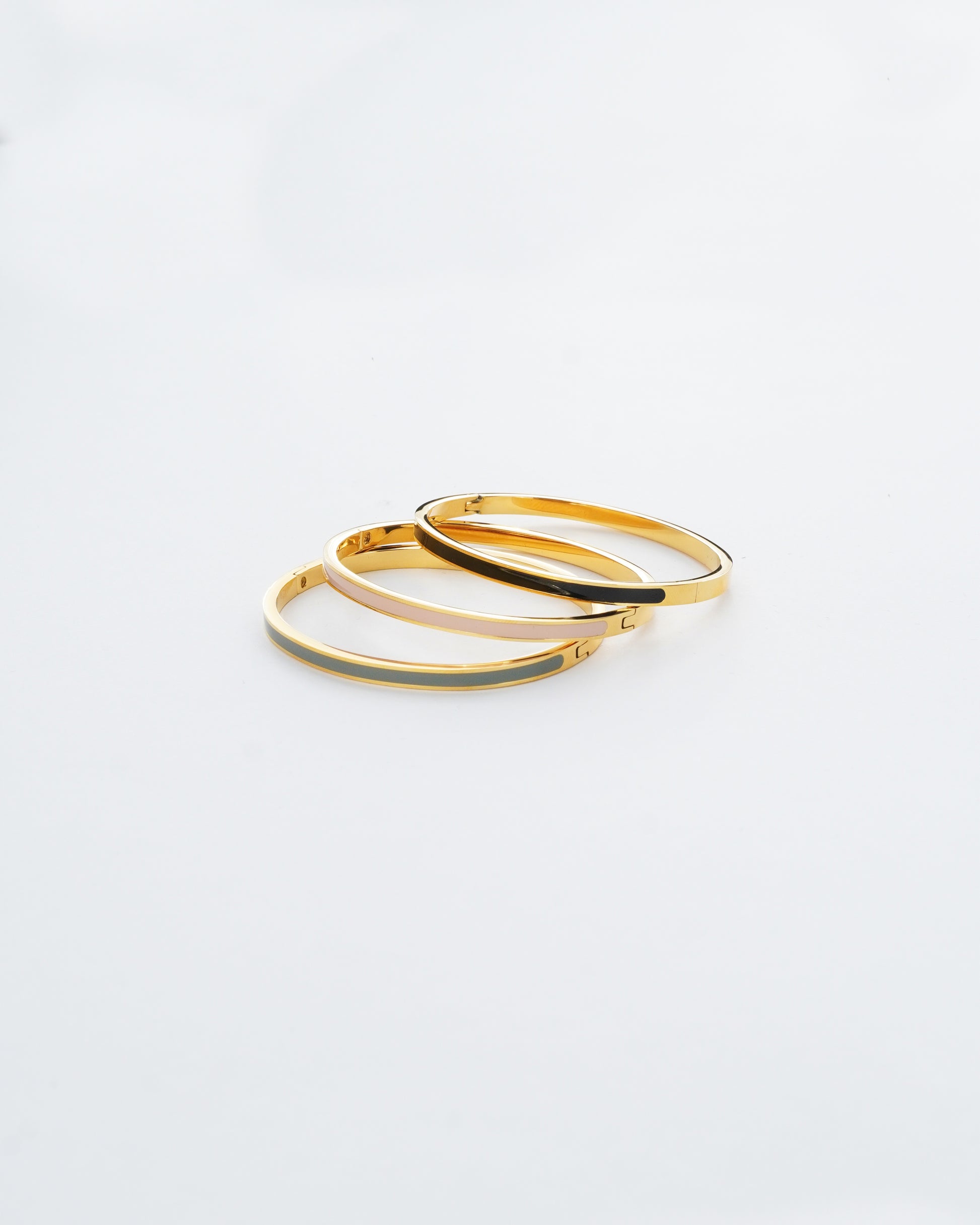 Two gold hoop earrings on a light gray background