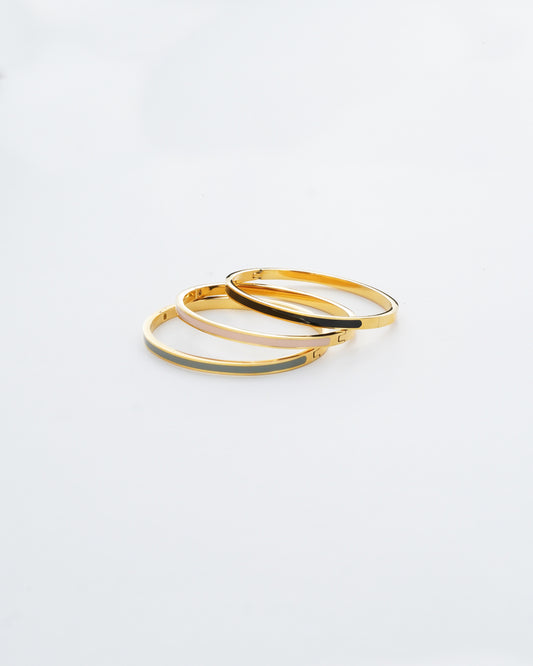 Two gold hoop earrings on a light gray background